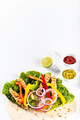 Ingredients for preparing tortilla with fresh vegetables, chicken and sauce. Flat lay view on white background.