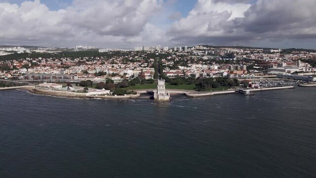 Aerial view of Belem tower along Tagus river, view of an iconic landmark with Belem district in background, Lisbon, Portugal.