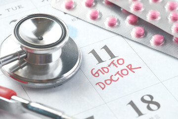 close up of medical pills and stethoscope on calendar ,