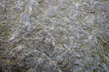 Eroded weathered colorful stone with rich texture of dust, grain and grunge scratches, marks and stains from natural conditions, weather.