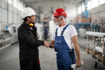 Portrait of workers in factory. Colleagues handshake in factory
