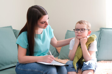 psychologist listens to a small child during a therapy session.