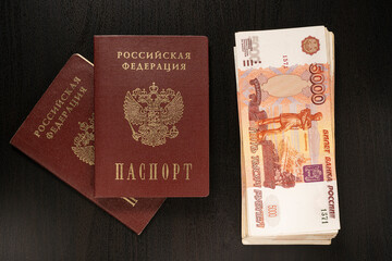 Russian banknotes of 5000 rubles. Passports of the Russian Federation on a dark background.