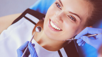 Young Female patient with pretty smile examining dental inspection at dentist office.