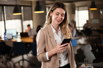 Businesswoman in office. Smiling businesswoman using the phone.