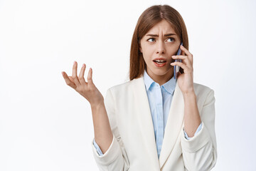 Confused corporate women talks on phone and look puzzled. Businesswoman cant understand speaker, calling someone, white background