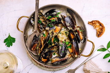 mussels in creamy sauce in a  frying pan.top view