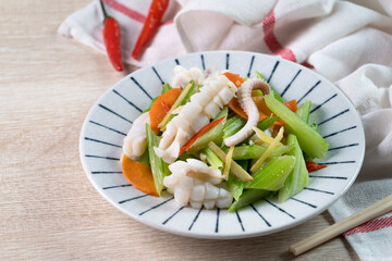 Stir-fried neritic squid with celery. Delicious homemade seafood with vegetable meal.