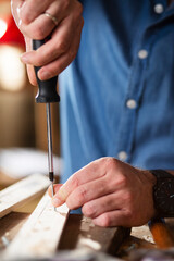 Close up of carpenter working on wood craft at workshop.