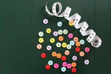 
Colorful buttons for shirts and blouses on green wooden background, as color concept and tailor material