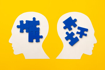 Obraz premium Papercut head silhouette with puzzle pieces on yellow background