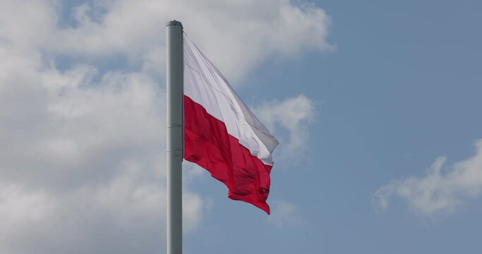  Polish flag on the mast. Beautiful Polish flag waving in a strong wind.