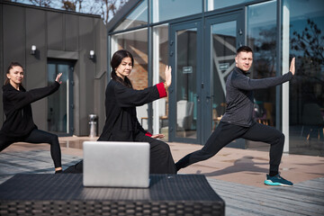 People checking with laptop the correct tai chi movement form
