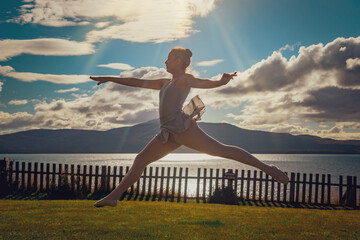 CLASSIC ARTISTIC DANCER DANCING ON THE COAST OF LAKE AT SUNSET