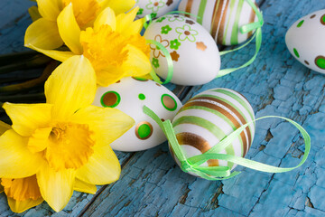 Colored decorative Easter eggs and a bouquet of yellow narcissus