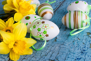 Colored decorative Easter eggs and a bouquet of yellow narcissus