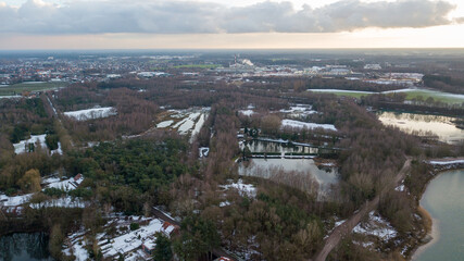 Obraz premium Aerial view of a beautiful and dramatic sunset over a forest lake reflected in the water, landscape drone shot. Blakheide, Beerse, Belgium. High quality photo