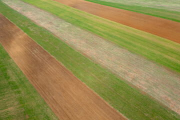 Aerial view about cultivated farm field at countryside, agriculture texture.