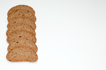 pieces of grey rye healthy bread, laid out in a row as a frame on the left on a white background