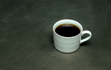 black coffee in a white cup on a gray background