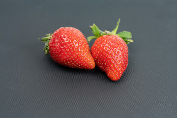 Red strawberries, close-up on a black background. Summer concept, harvest, there is a place for text
