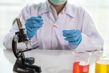 Fototapeta premium Scientist drop a sample on glass slide in medical laboratory, Science and chemistry, Researcher test a sample concept