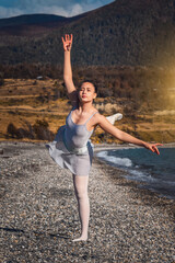Obraz premium CLASSIC ARTISTIC DANCER DANCING ON THE COAST OF LAKE AT SUNSET