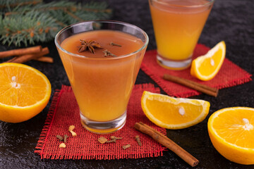 Mulled wine with orange juice and spices decorated with a New Year's composition on a black...