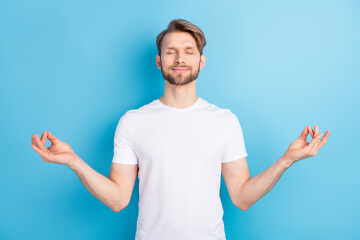 Portrait of satisfied young man closed eyes hands fingers meditate isolated on blue color background