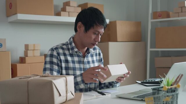 online business owner is checking the validity of packages before delivery. owner is writing down the product codes in a book to check the order list and inventory. Shipping management concepts.