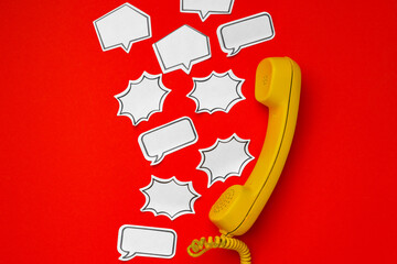 Yellow telephone speaker and speech bubble on red background
