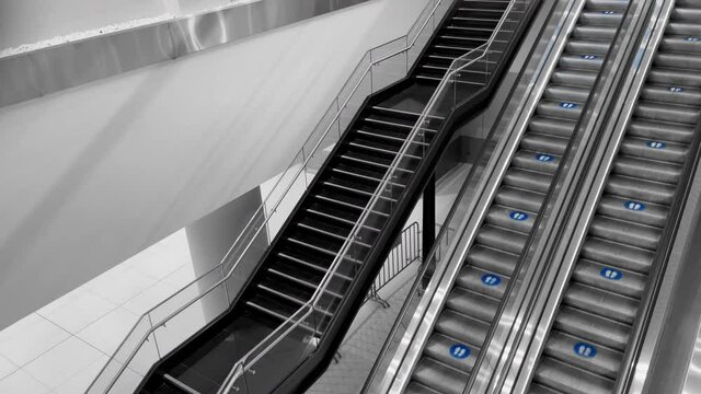 4K foot prints for keep social distancing symbols on escalator steps of new normal behavior for safety in covid-19 coronavirus pandemic time in Shopping building or modern. Urban lifestyle video.