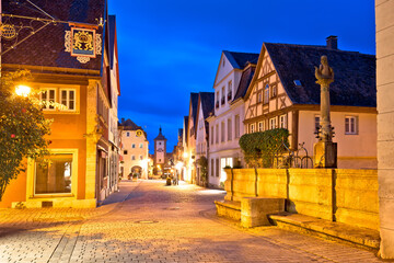 Rothenburg ob der Tauber. Hisoric tower gate and cobbled street of medieval German town of Rothenburg ob der Tauber evening view