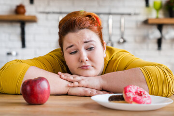 Sad plump fat woman choosing between sweets and fruits, healthy eating and junk food. The choice....