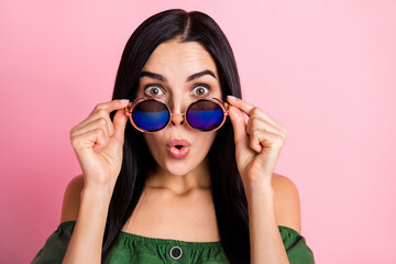 Close-up portrait of attractive amazed cheerful girl touching specs pout lips isolated over pink pastel color background