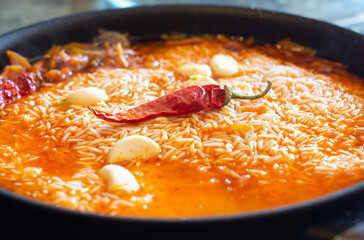 Cooking pilaf. Rice with vegetables in a frying pan. Central-Asian cuisine.