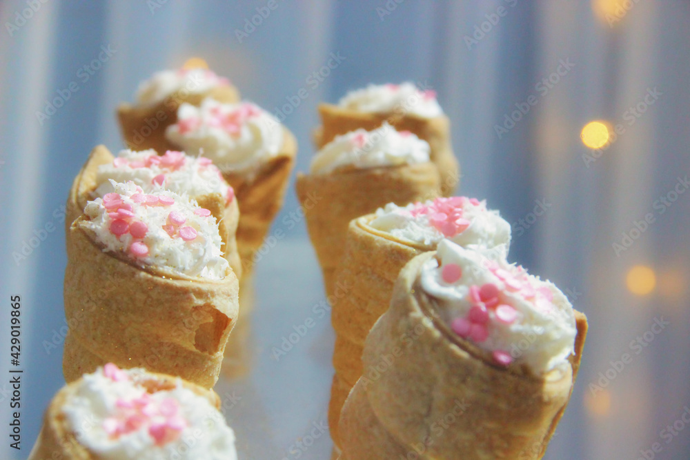 Sticker closeup of two lines of ice cream with pink sprinkles on it and orange bokeh in the background