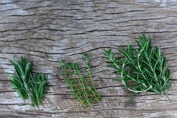 Rosemary, lavender, and thyme fresh herbs bunch on Natural wood background. Top view, flat lay. Healthy eating and alternative medicine concept