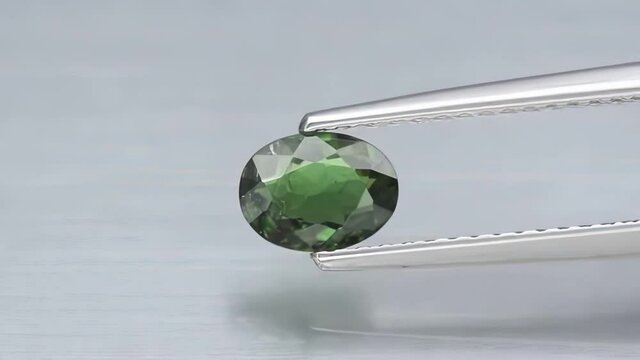 natural green chrome tourmaline in the tweezers on the turn table