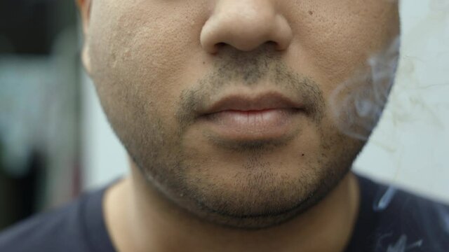 Young men smoking He smoked and spat out a lot of smoke. It is dangerous to the people around. World No Tobacco Day.