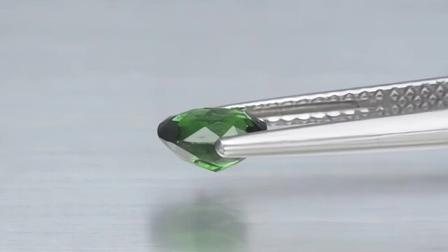 natural green chrome tourmaline in the tweezers on the turn table