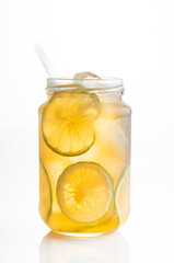 Iced tea with lemon in glass jar on white background and lemon slices