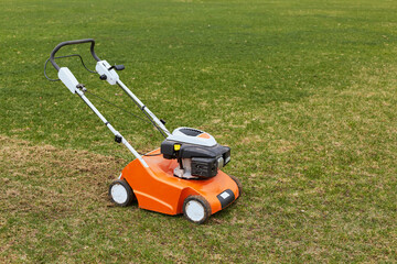 Lawn mover on green grass on background of field or garden. Machine for cutting lawns. Grass-cutter...