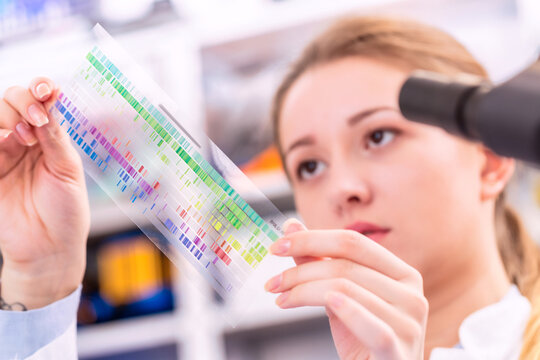 Young woman examines a spectroscopy picture in a quantum physics laboratory