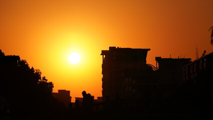 Obraz premium The beautiful sunset view with the golden sunlight in the city
