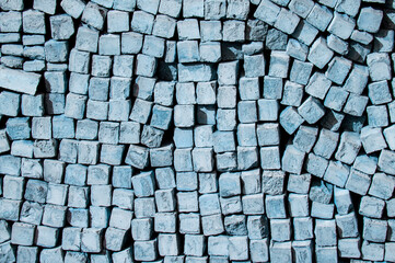 cobblestone piled in a heap. brick gray wall. dark unusual texture. blue geometric background