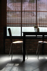 Modern chair and square wooden table near window in the cafe.