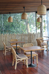 Rattan chair and wooden table on wooden floor in the restaurant.