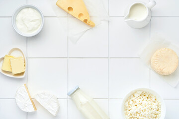 Glass of milk, cottage cheese, ricotta, sour cream, cheese, camembert and butter on white table background. Different dairy products. Milk concept. Top view with copy space. Mock up.