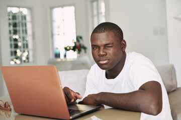 handsome man of african appearance looking at laptop monitor education manager freelancer